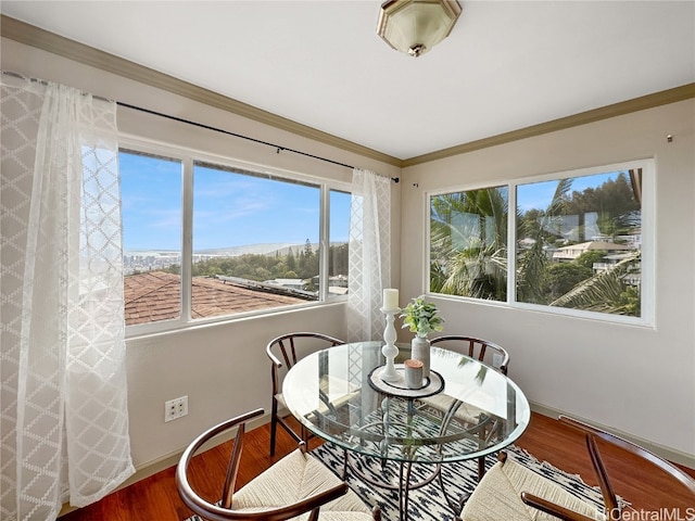 dining area with ornamental molding and hardwood / wood-style floors