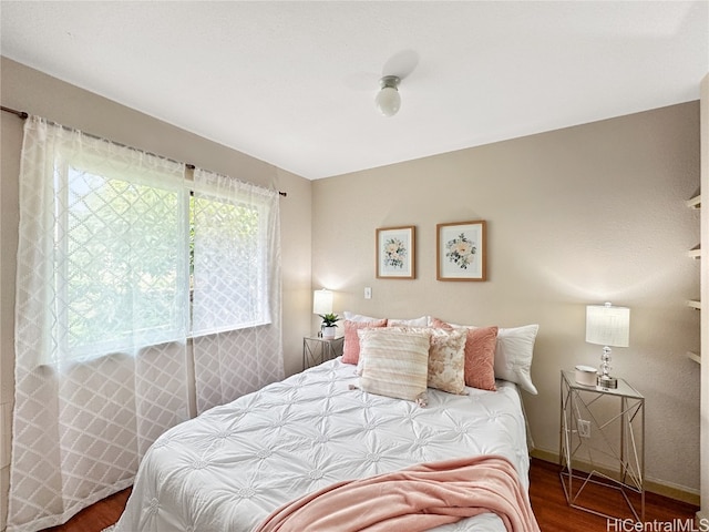 bedroom with dark hardwood / wood-style flooring