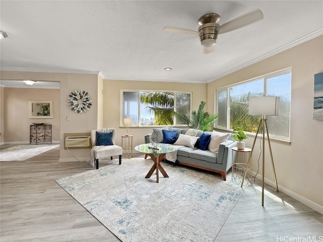 living room featuring ornamental molding, a textured ceiling, light wood-type flooring, and ceiling fan