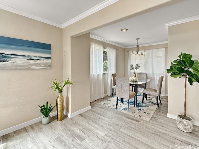 dining space featuring light hardwood / wood-style floors and crown molding