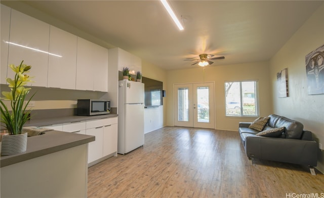 kitchen with french doors, light hardwood / wood-style flooring, white refrigerator, white cabinets, and ceiling fan