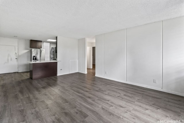 unfurnished living room featuring dark hardwood / wood-style floors and a textured ceiling