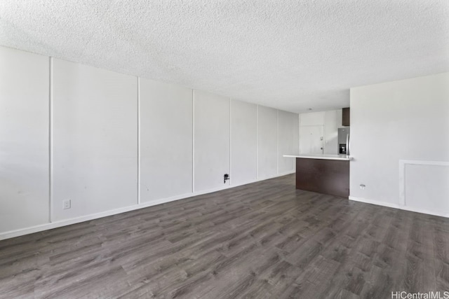 unfurnished room with a textured ceiling and dark hardwood / wood-style flooring