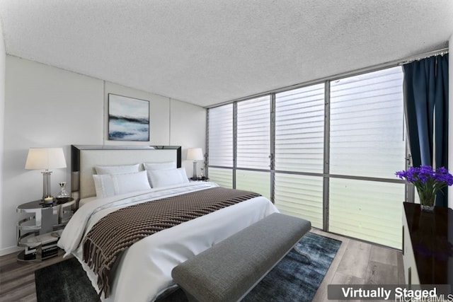 bedroom featuring a wall of windows, a textured ceiling, and wood-type flooring