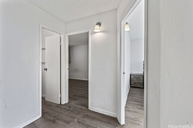 hall featuring a textured ceiling and dark hardwood / wood-style floors