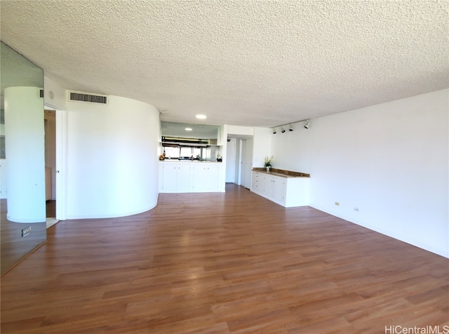 empty room featuring wood-type flooring and a textured ceiling