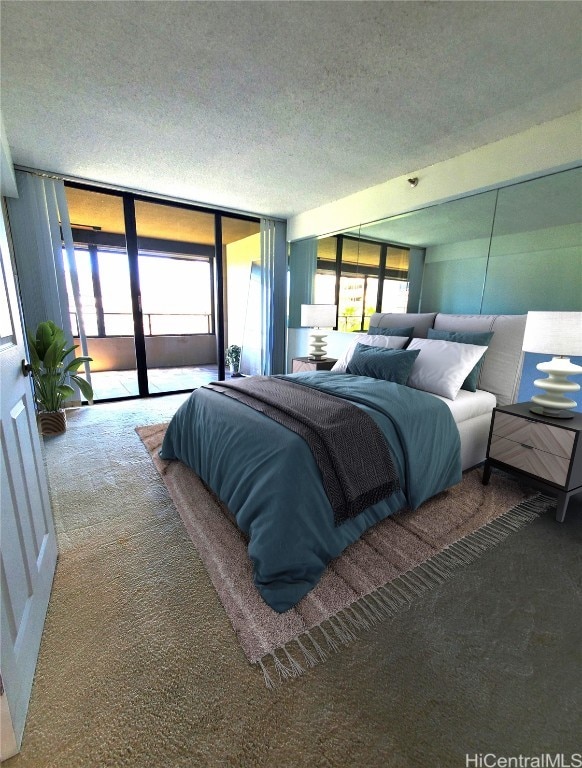 carpeted bedroom with access to outside, a textured ceiling, and floor to ceiling windows