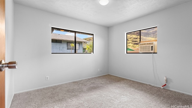 carpeted spare room with cooling unit and a textured ceiling