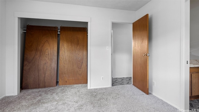 unfurnished bedroom featuring a closet and light carpet