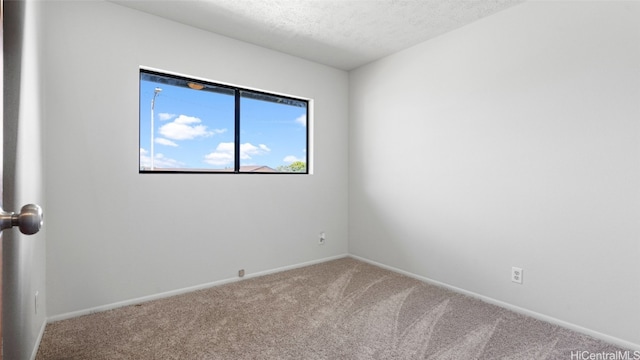 unfurnished room with a textured ceiling and carpet floors