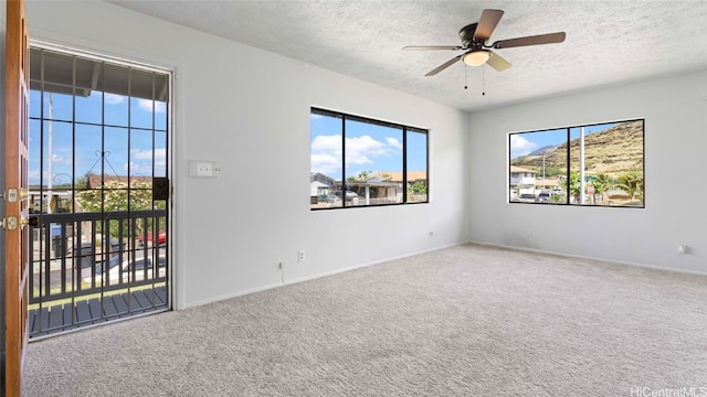 empty room with a textured ceiling, carpet flooring, and ceiling fan