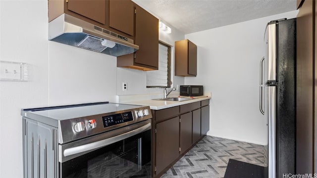 kitchen with dark brown cabinets, a textured ceiling, appliances with stainless steel finishes, and sink