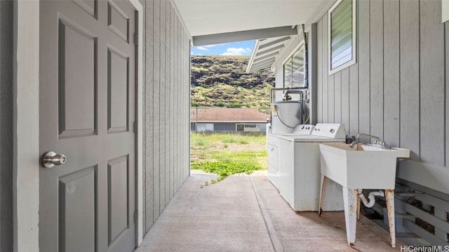 washroom with washer / dryer and wooden walls