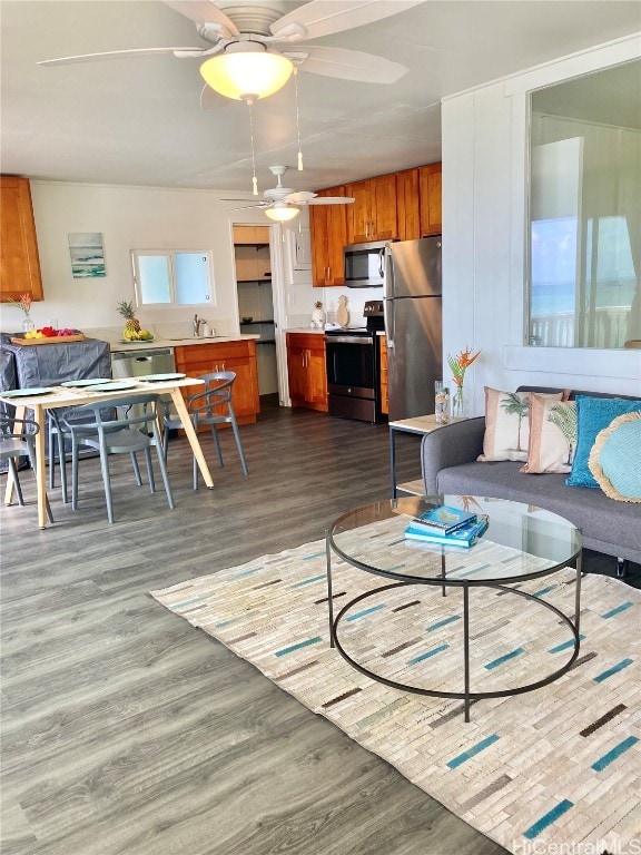 living room featuring sink, wood-type flooring, and ceiling fan