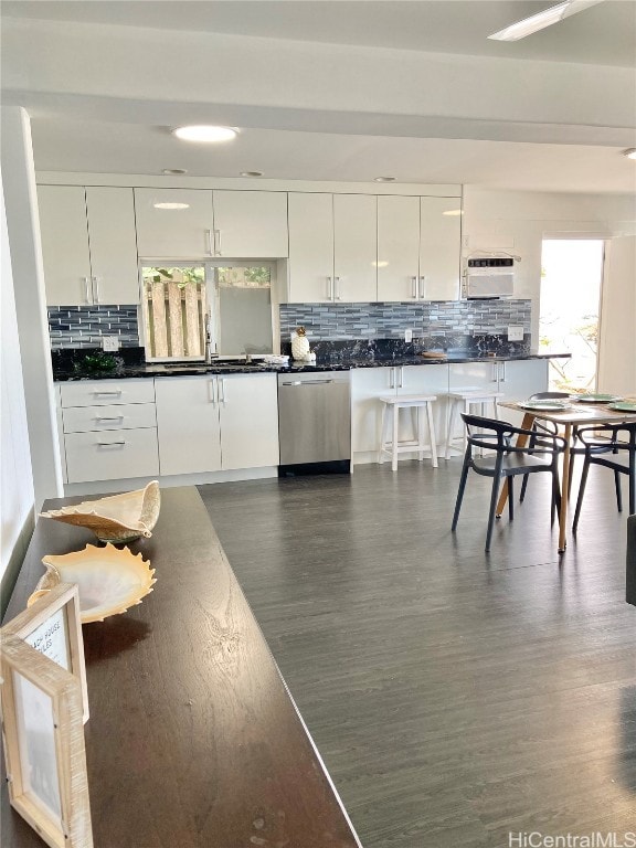 kitchen featuring dishwasher, dark hardwood / wood-style floors, backsplash, sink, and white cabinetry