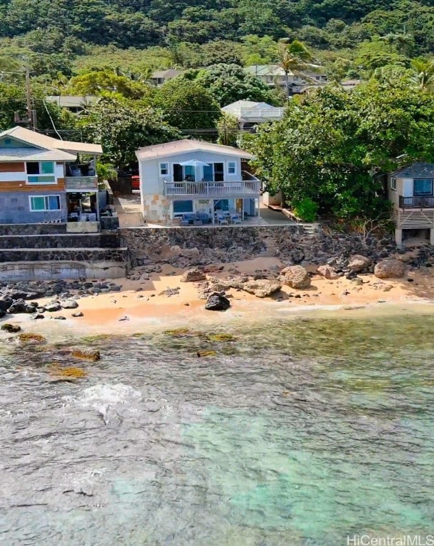 exterior space with a water view and a beach view