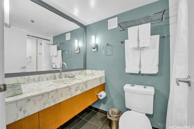 bathroom featuring walk in shower, vanity, toilet, and tile patterned flooring