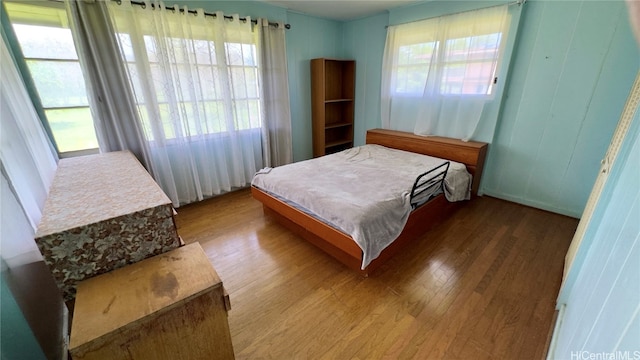 bedroom with hardwood / wood-style flooring and multiple windows