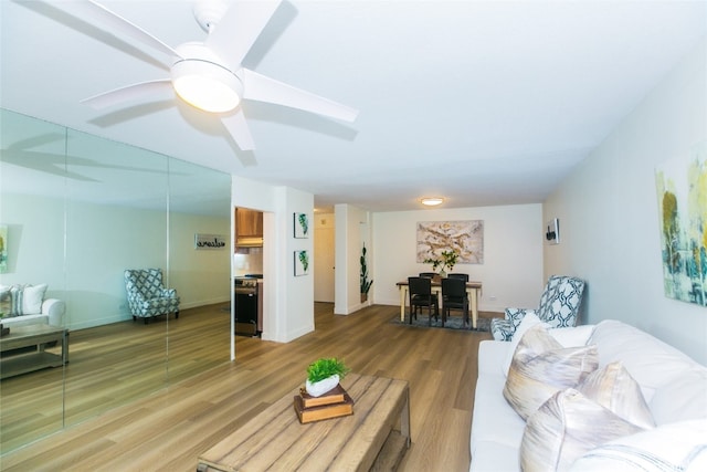 living room featuring hardwood / wood-style floors and ceiling fan