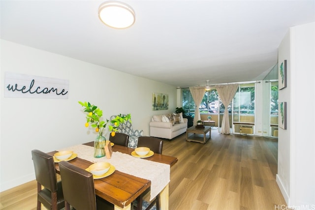 dining room featuring a wall mounted air conditioner and hardwood / wood-style floors