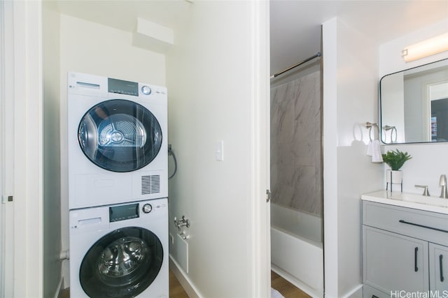 laundry room with stacked washer and clothes dryer and sink