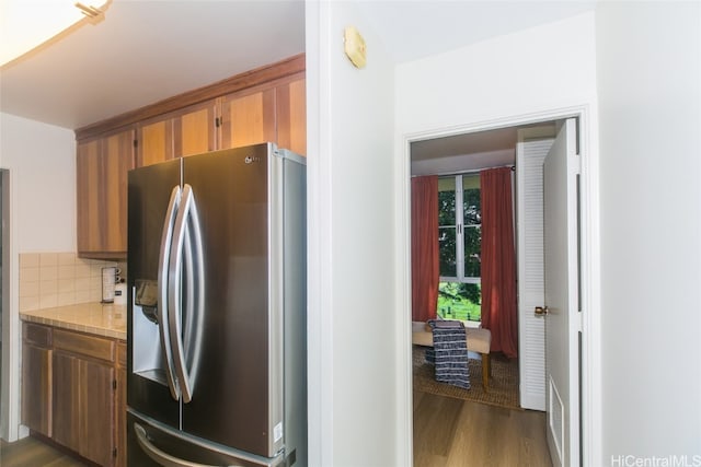 kitchen featuring tasteful backsplash, dark hardwood / wood-style flooring, and stainless steel fridge