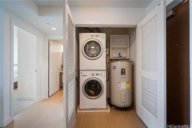 clothes washing area with stacked washer / drying machine and electric water heater