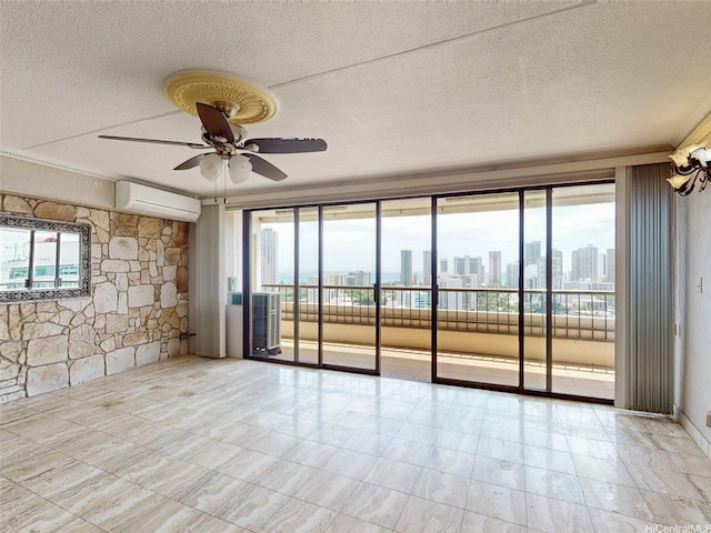 spare room featuring plenty of natural light, a ceiling fan, an AC wall unit, and a textured ceiling