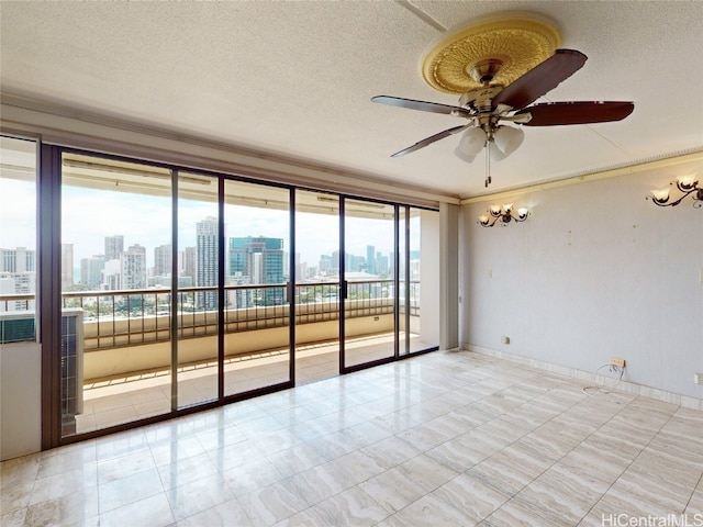 unfurnished room featuring a wall of windows, a textured ceiling, and ceiling fan