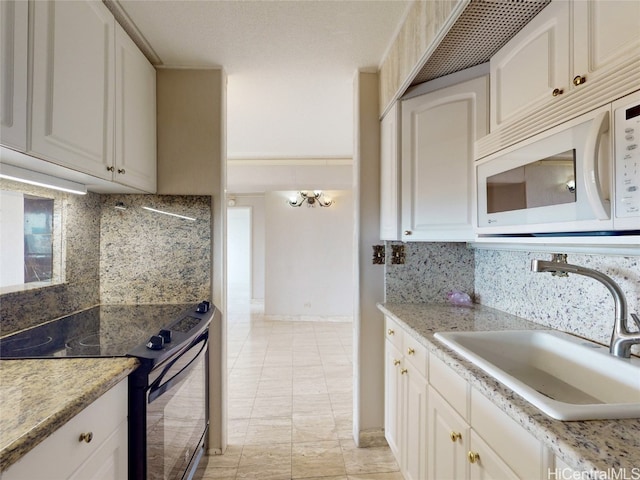 kitchen with sink, light tile patterned flooring, stainless steel range with electric cooktop, white cabinets, and tasteful backsplash