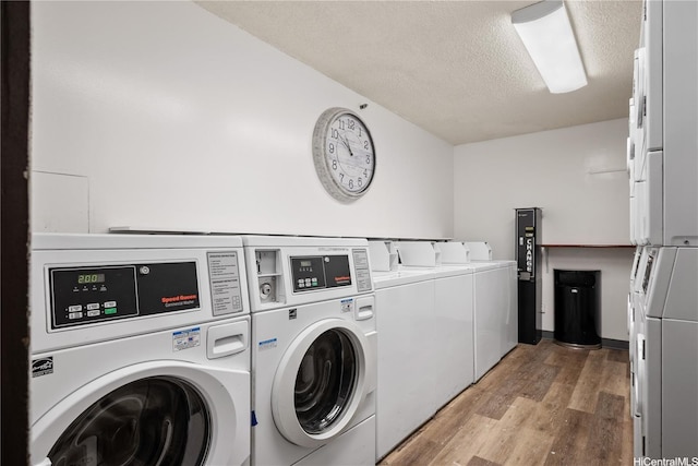 shared laundry area featuring washer and dryer, a textured ceiling, and light wood-style flooring
