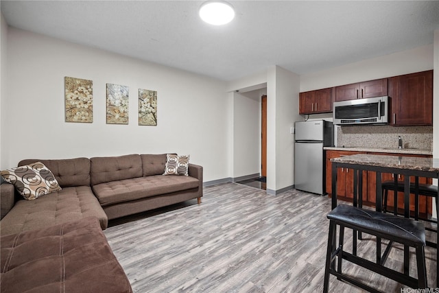 living area with baseboards and light wood-type flooring