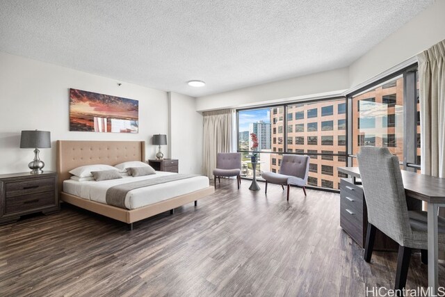 bedroom with a textured ceiling and wood finished floors