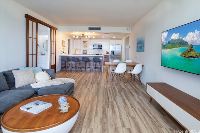 living room featuring light wood-type flooring and sink