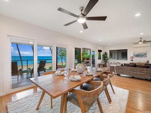 dining space with recessed lighting, a ceiling fan, a wall unit AC, and light wood-style floors