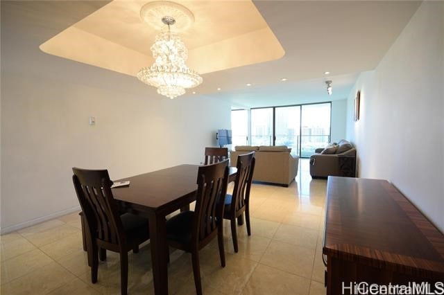 dining space with a chandelier and a tray ceiling