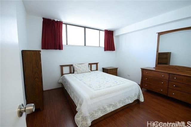 bedroom with dark hardwood / wood-style floors