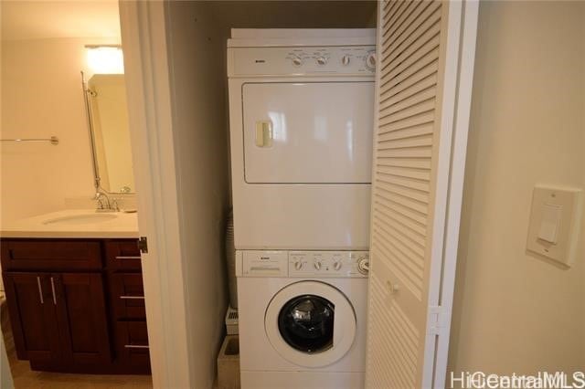 laundry area with stacked washer / dryer and sink