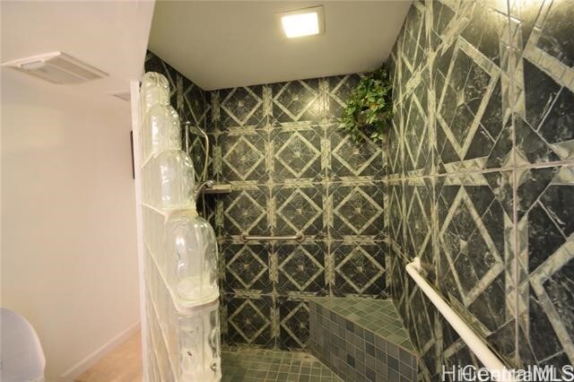 bathroom featuring a tile shower and tile patterned floors