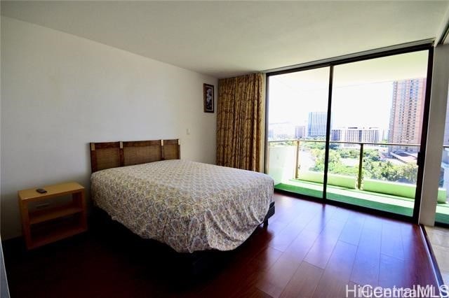 bedroom featuring expansive windows and dark hardwood / wood-style floors