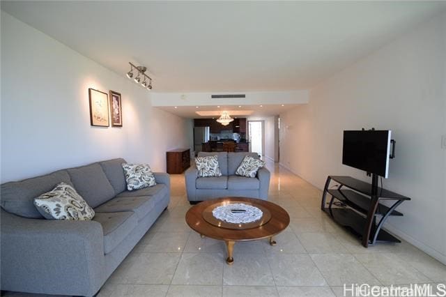 living room with a notable chandelier and tile patterned floors