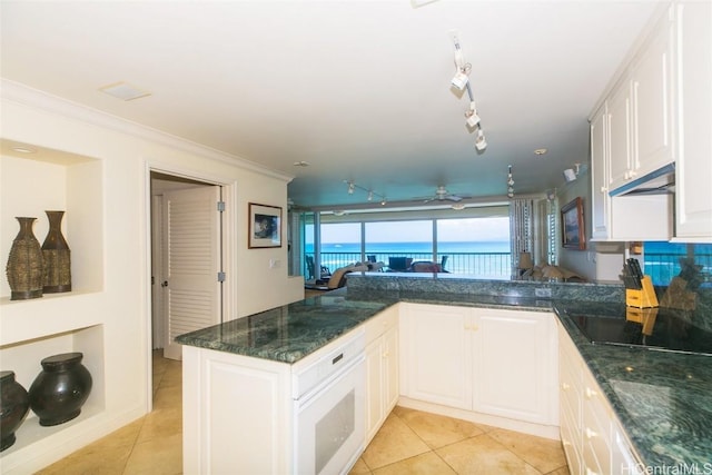 kitchen with white cabinets, a water view, and kitchen peninsula