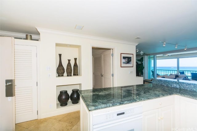 kitchen with rail lighting, dark stone countertops, white cabinetry, and crown molding