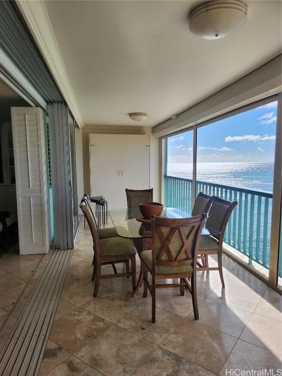 sunroom featuring a water view