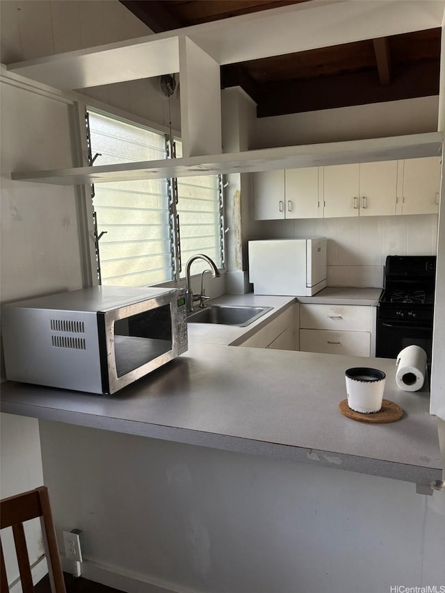 1629 Kino St Unit F, Honolulu, HI 96819 - kitchen featuring a sink, stainless steel microwave, black gas range oven, freestanding refrigerator, and beam ceiling