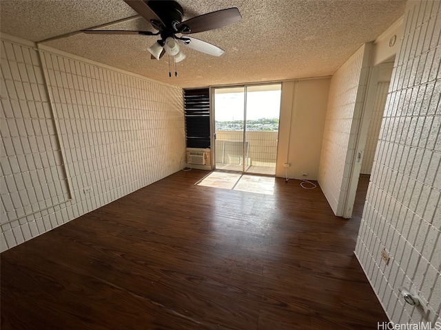 empty room with dark hardwood / wood-style flooring, a textured ceiling, and ceiling fan