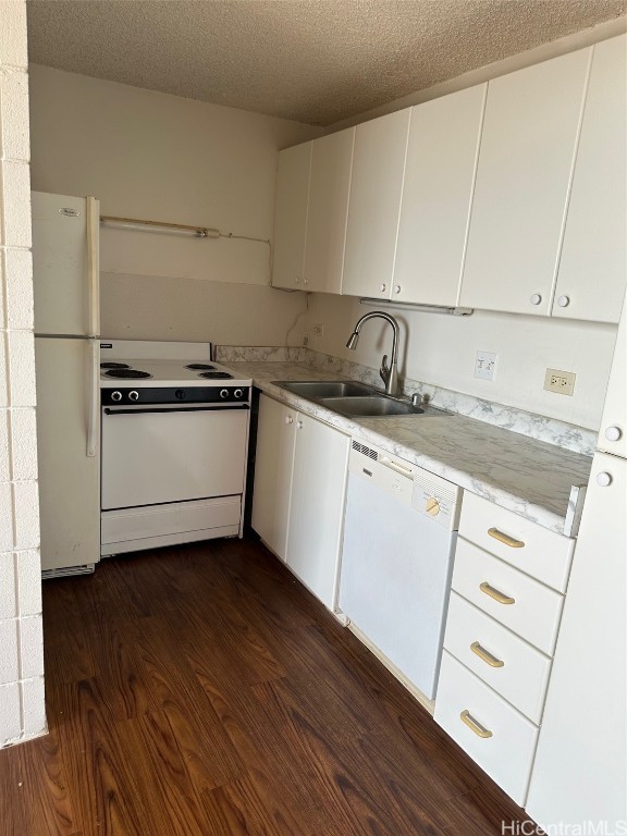 kitchen with dark hardwood / wood-style flooring, white appliances, sink, and a textured ceiling