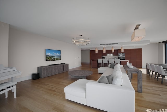 living room with light hardwood / wood-style flooring and an inviting chandelier