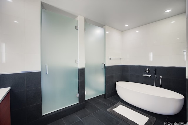 bathroom featuring vanity, tile patterned floors, tile walls, and separate shower and tub