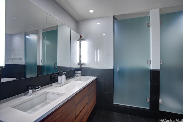 bathroom featuring vanity, a shower with shower door, tile patterned floors, and tile walls